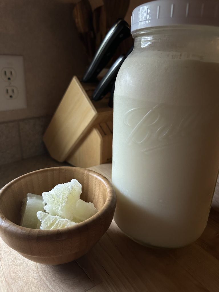 jar of raw milk sitting next to whey cubes in a bowl 