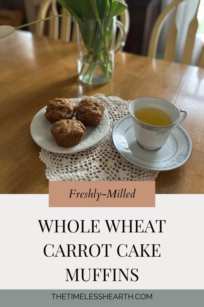 Muffins sitting on a table next to a vase of flowers 