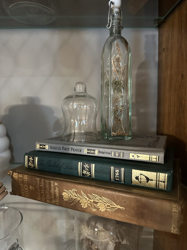 Vintage linen books on shelf with decor