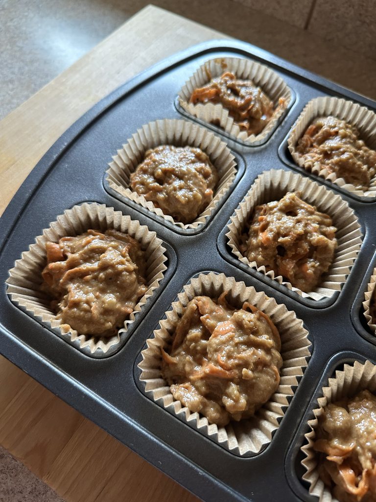 Muffin mix in muffin tin uncooked on counter
